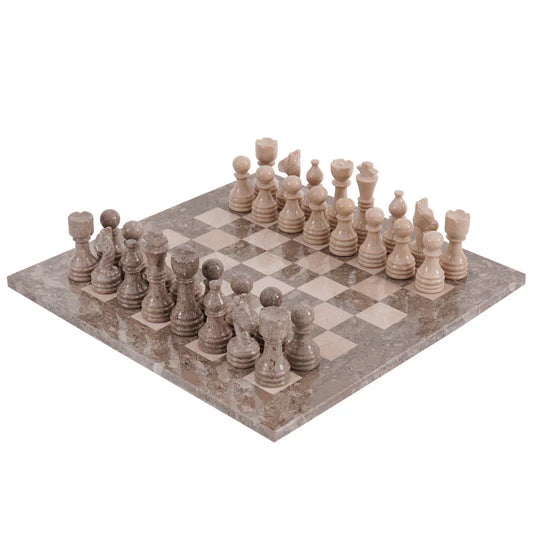 A marble chess set with pieces arranged on the board, including kings, queens, knights, bishops, rooks, and pawns. The set is displayed on a checkered patterned surface.