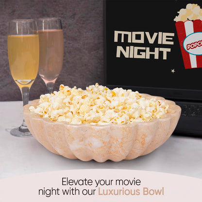 Bowl of popcorn with two glasses of champagne and a laptop displaying 'Movie Night' and 'Popcorn'.