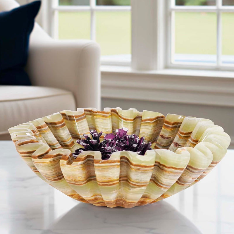Decorative shell bowl with purple flowers on a marble surface in a home setting.