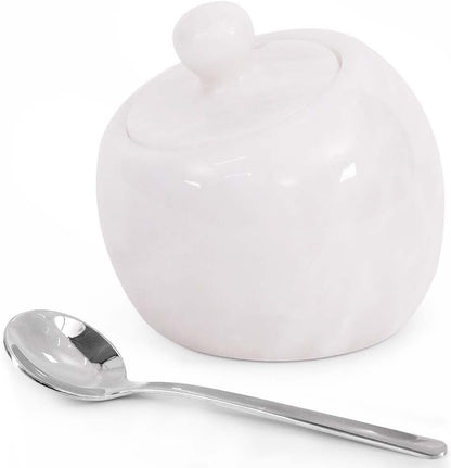 White ceramic sugar bowl with a lid and a silver spoon on a white background