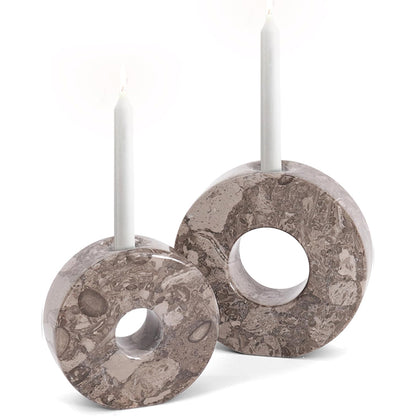 Two marble-patterned candle holders with white candles on a white background