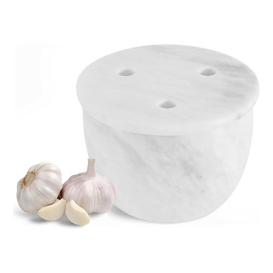 White ceramic garlic press with two cloves of garlic on a white background