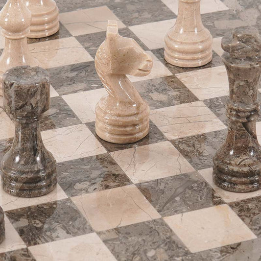 Marble chess set with chess board and pieces made of onyx stone, displayed on a surface with a checkered pattern.
