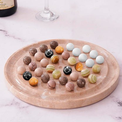 Wooden tray with assorted marbled stones on a marble surface