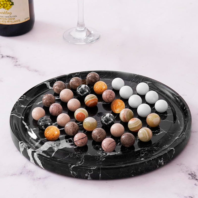 Marble-patterned tray with colorful marbles on a marble surface