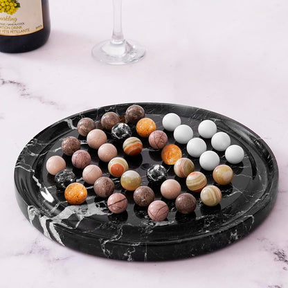 Marble-patterned tray with colorful marbles on a marble surface