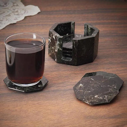A set of marble star-shaped coasters with one holder, displayed on a wooden surface, with one coaster being used to hold a glass of liquid.