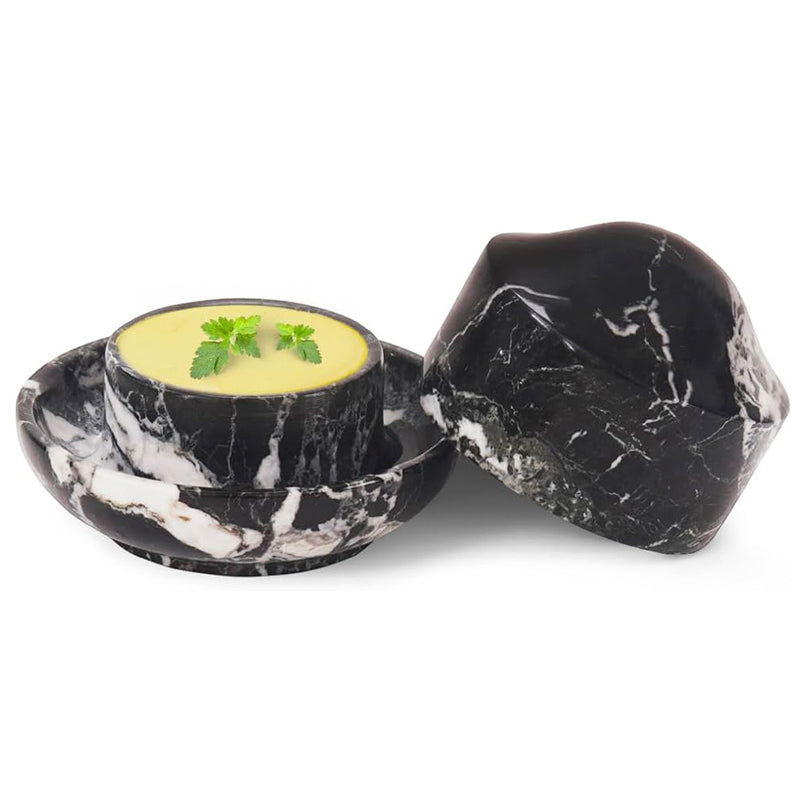 Black marble bowl with a small dish of soup on a white background