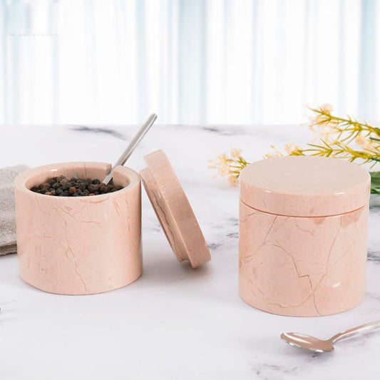 Marble-textured pink containers with lids on a marble surface.