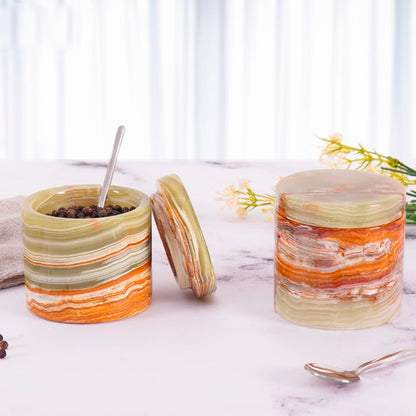 Decorative jars with striped patterns on a marble surface