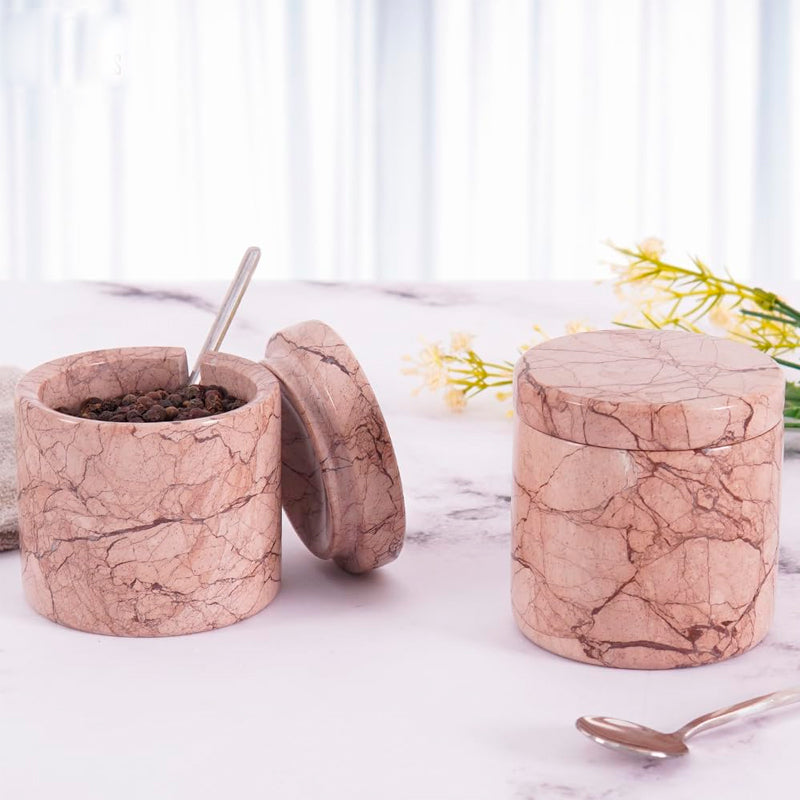 Marble-patterned containers on a marble surface with a blurred background