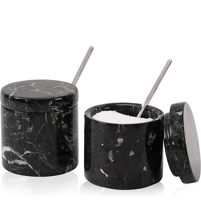 Black marble salt shaker with a spoon inside on a white background