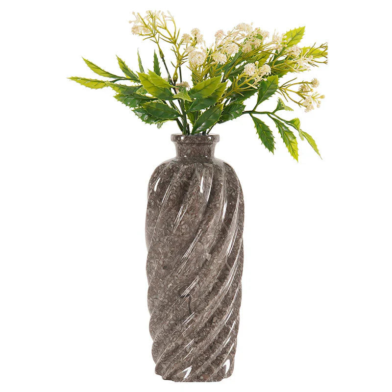 Decorative vase with a textured pattern containing artificial flowers on a white background